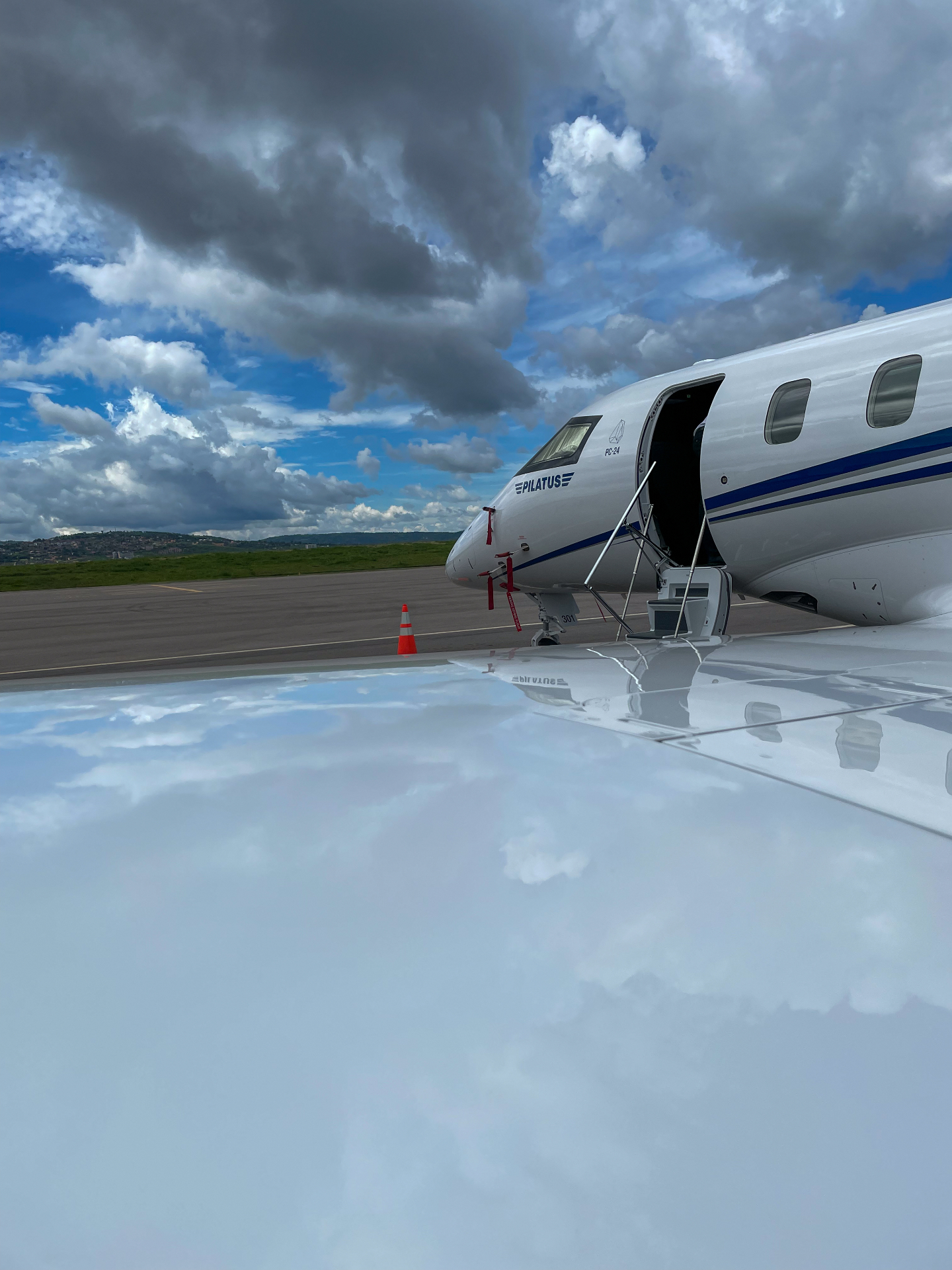 Pilatus PC-24 with open door on dramatic cloudy tarmac